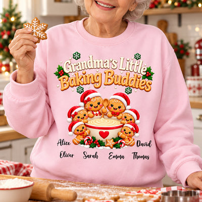Grandma's Little Baking Buddies Personalized Sweatshirt worn by a smiling woman holding a snowflake cookie in a kitchen