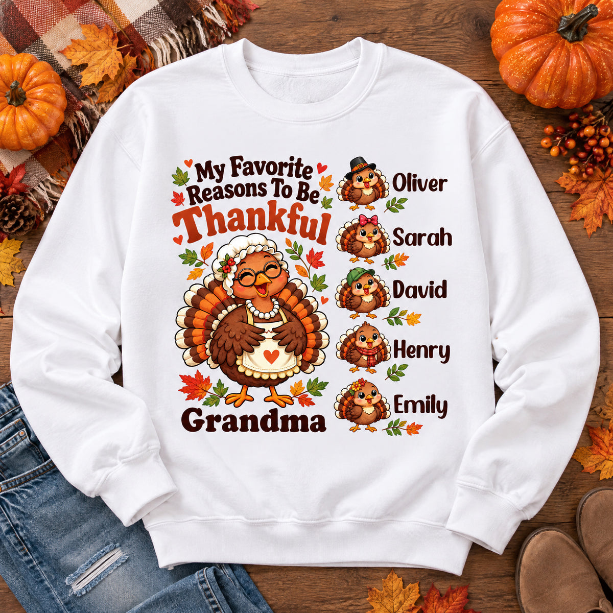 Personalized Sweatshirt My Favorite Reasons To Be Thankful flat on a wood table with five turkey names, jeans and leaves