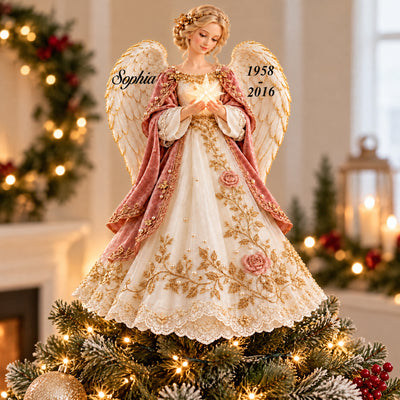 Personalized Angel Tree Topper on a frosted tree with gold ornaments, garland and a lantern in the background