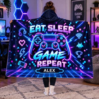 Personalized wearable hooded blanket held open by a person in a gaming room with neon hexagon lights