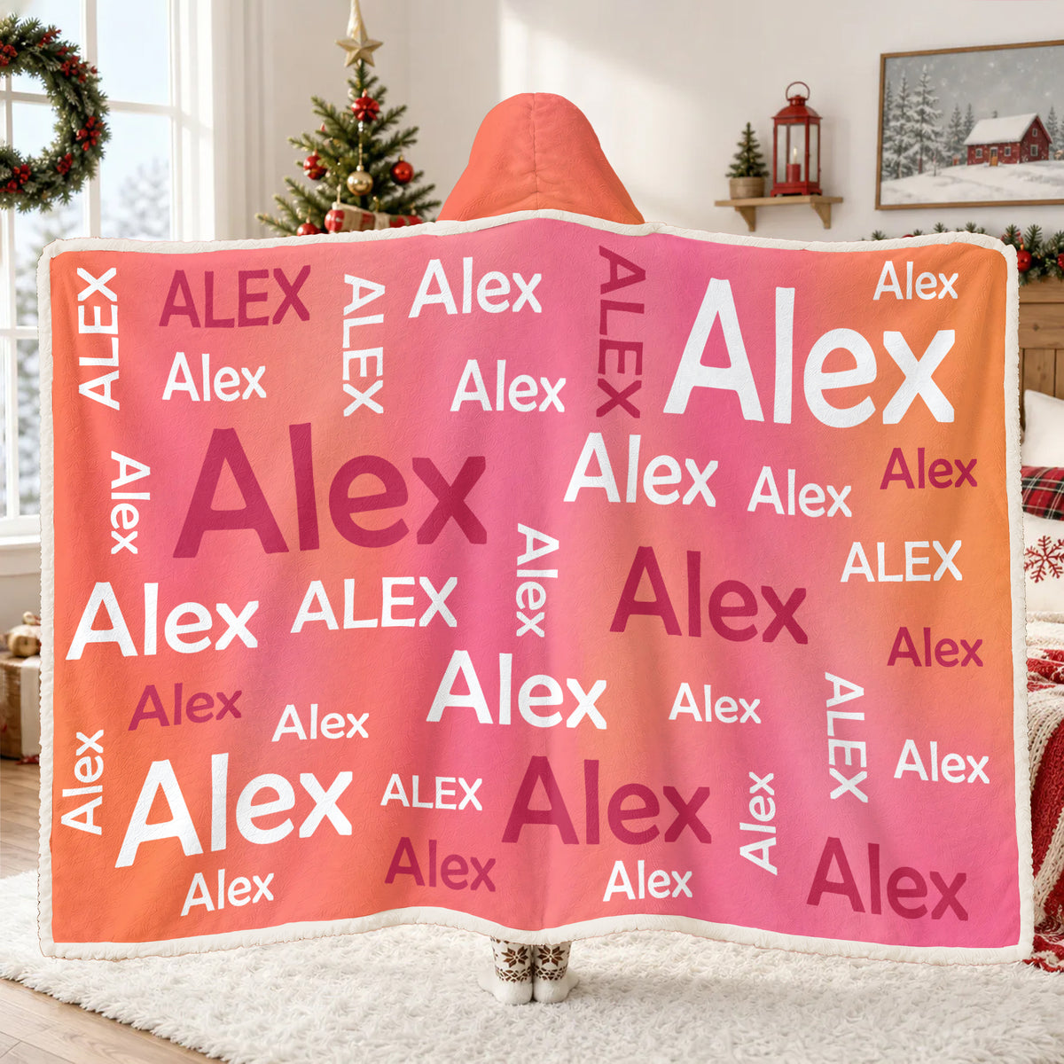 Personalized Wearable Hooded Blanket in pink and orange with Alex names, seen from behind near a holiday window
