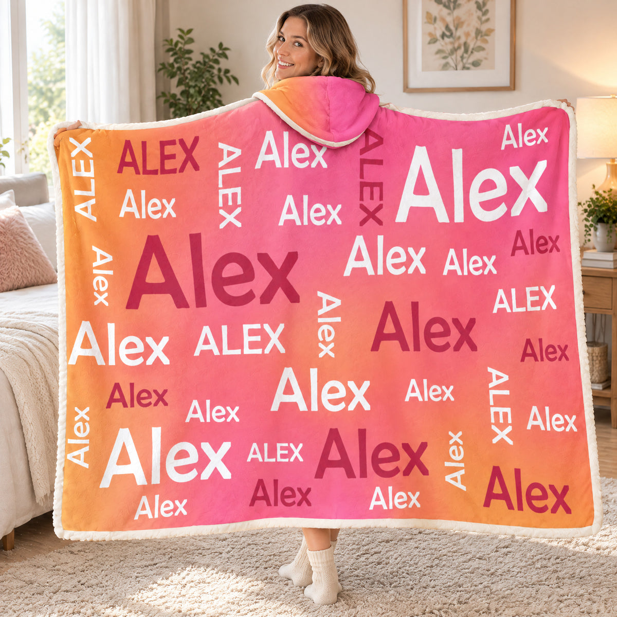 Personalized Wearable Hooded Blanket with Alex names held open by a smiling woman looking over her shoulder in a bedroom
